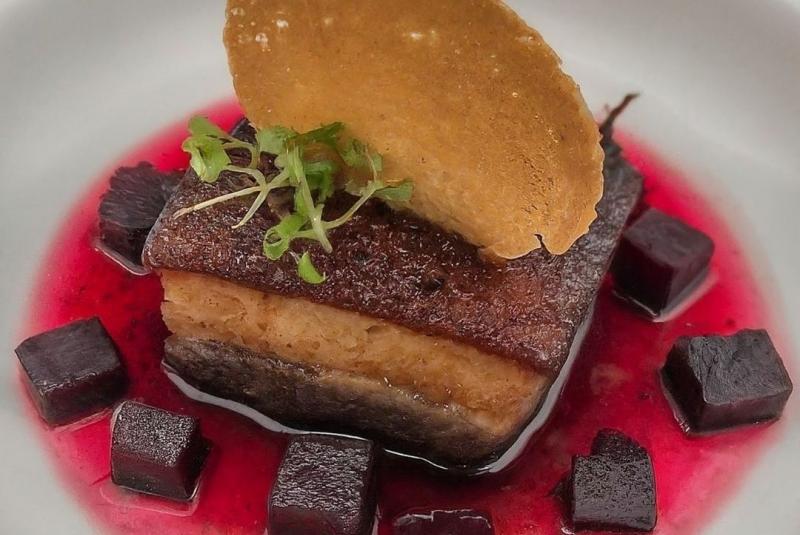 Poitrine de cochon noir confite à l’ail noir, betteraves et tuile de chèvre. 